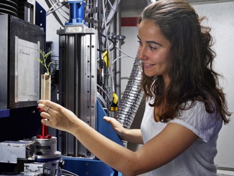 Close up photo of scientist setting up her experiment inside large equipment 