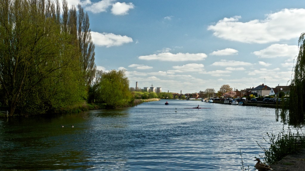 White cooling towers in the distance above the curve of the River Thames