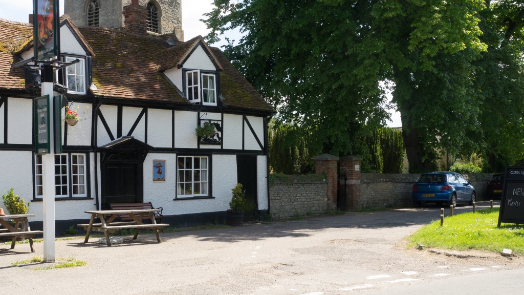 Timber framed pub with church tower behind