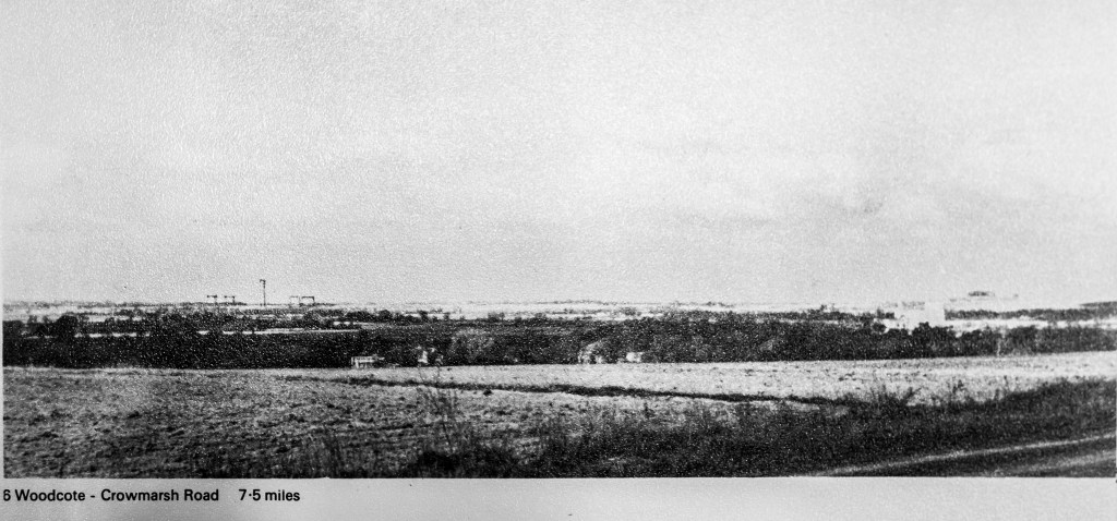 Black and white photo with tops of cooling towers drawn above hills