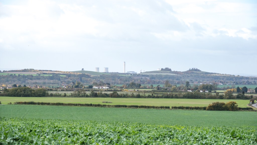 White cooling towers are seen behind the hills of Wittenham Clumps